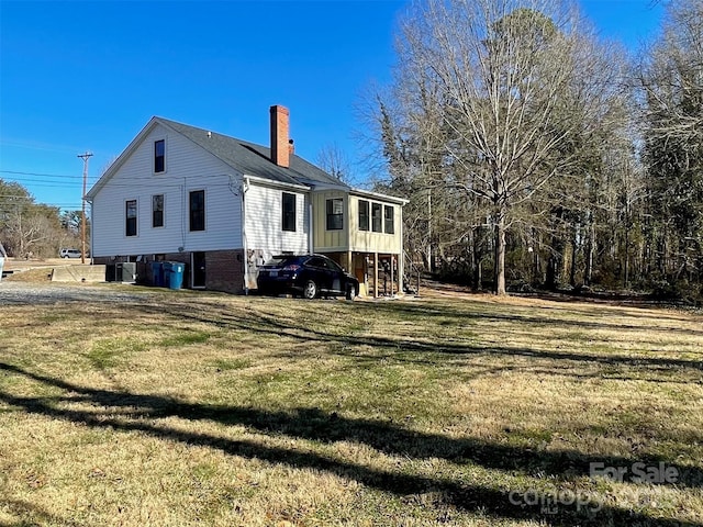 back of property featuring a yard and central AC unit