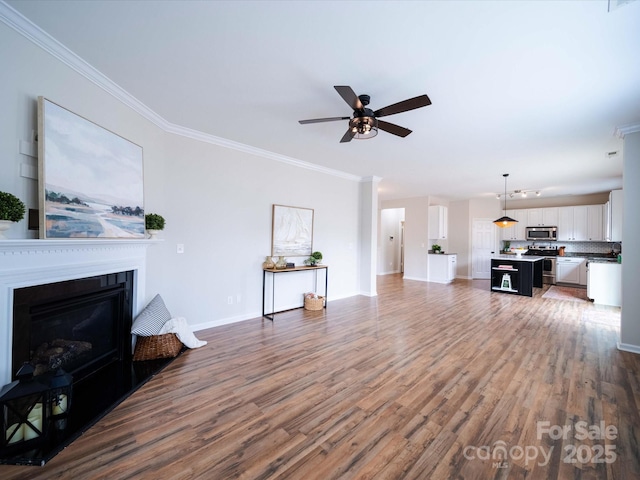 unfurnished living room featuring ornamental molding, dark hardwood / wood-style floors, and ceiling fan