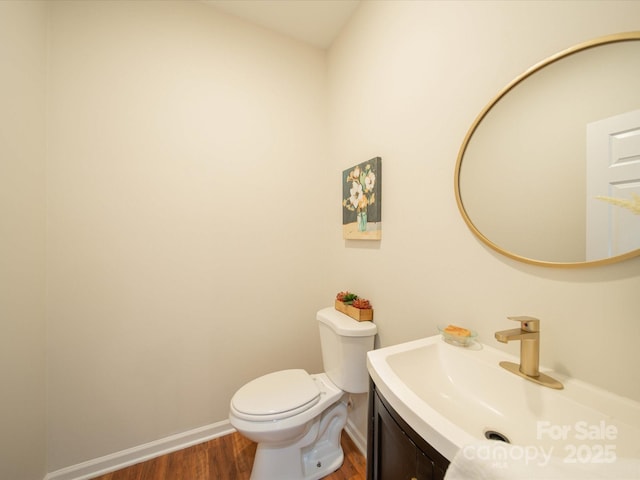 bathroom featuring wood-type flooring, toilet, and vanity