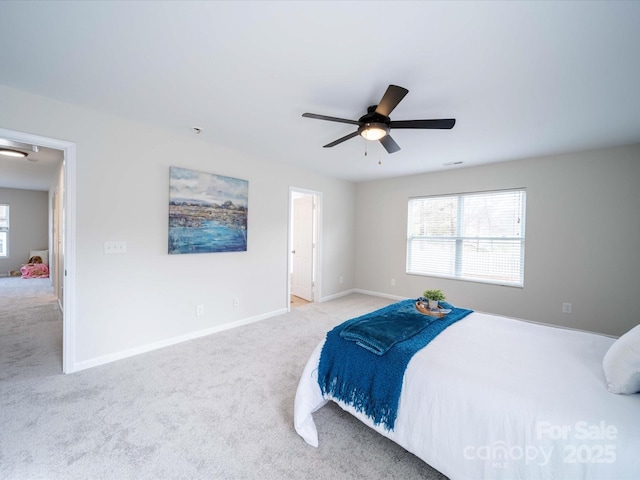 bedroom featuring multiple windows, light carpet, and ceiling fan