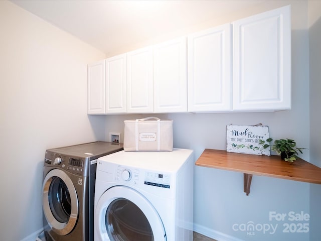 clothes washing area with separate washer and dryer and cabinets