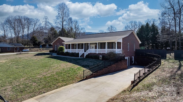 ranch-style house featuring covered porch and a front lawn