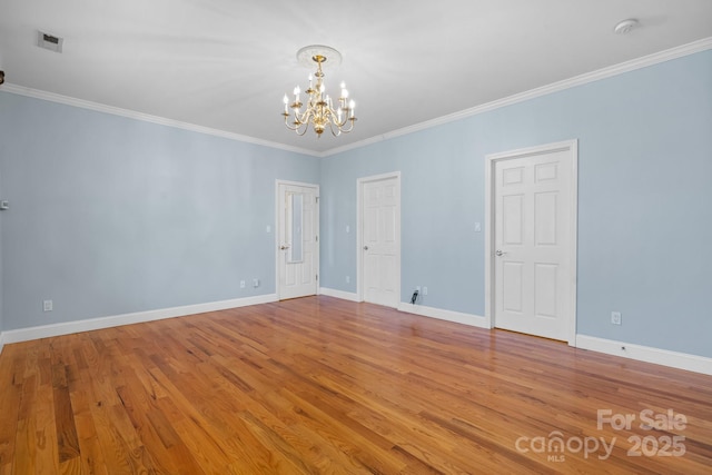 spare room with crown molding, a chandelier, and light hardwood / wood-style floors