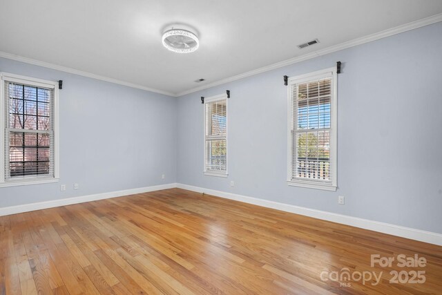 spare room featuring ornamental molding and light hardwood / wood-style flooring