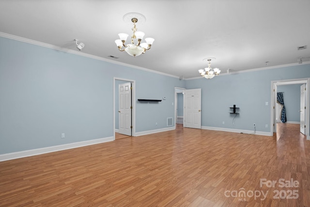 unfurnished room featuring crown molding, light hardwood / wood-style flooring, and a chandelier