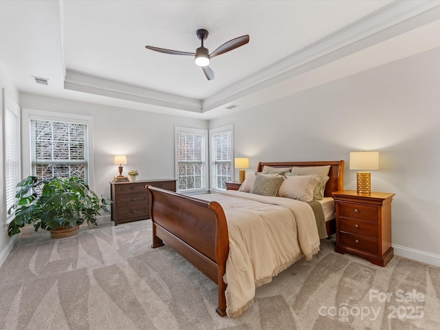 carpeted bedroom featuring ceiling fan and a tray ceiling