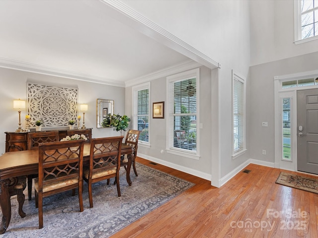 dining area with wood-type flooring and ornamental molding