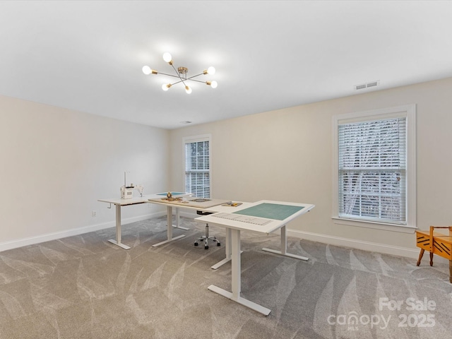 carpeted office with a notable chandelier