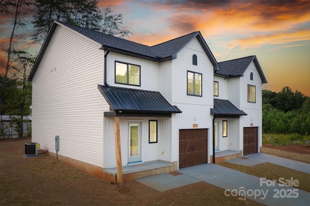 modern farmhouse featuring a garage and central air condition unit