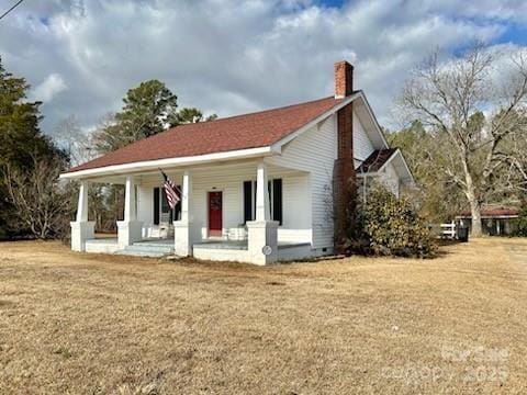 exterior space featuring a lawn and covered porch