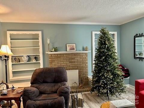 living area featuring crown molding, wood-type flooring, and a textured ceiling