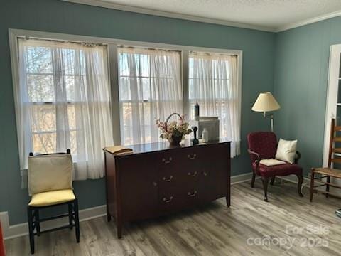 sitting room with hardwood / wood-style flooring, a wealth of natural light, ornamental molding, and a textured ceiling