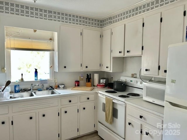 kitchen featuring white cabinetry, sink, and white appliances