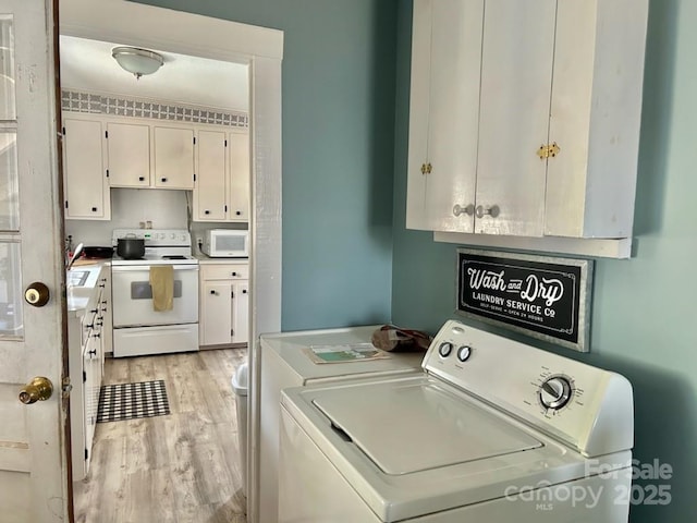 laundry area with separate washer and dryer and light wood-type flooring