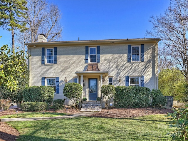 colonial home featuring a front lawn