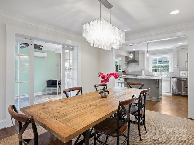 dining room with hardwood / wood-style floors, an inviting chandelier, and ornamental molding