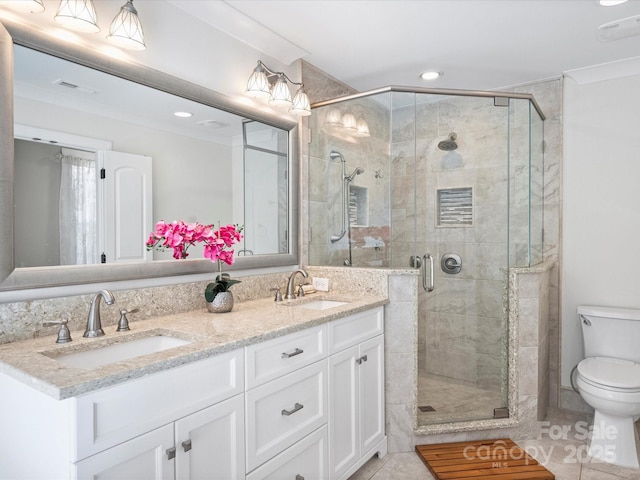 bathroom with crown molding, tile patterned floors, toilet, a shower with shower door, and vanity