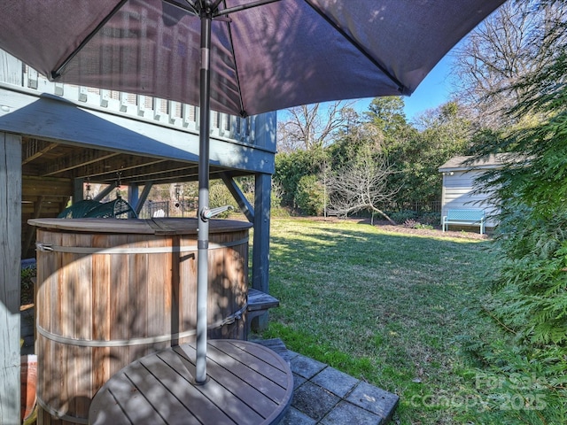 wooden deck with a hot tub and a yard