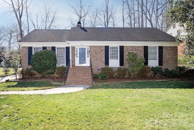 single story home with brick siding, a chimney, a front lawn, and roof with shingles