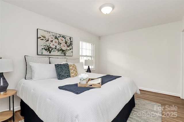 bedroom with baseboards and wood finished floors