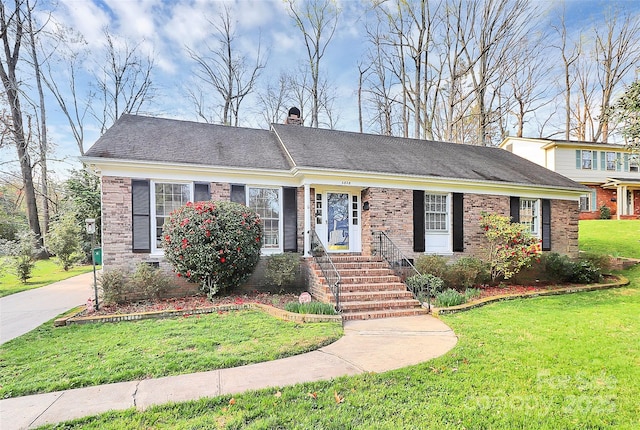 ranch-style house with brick siding, a front lawn, a shingled roof, and a chimney