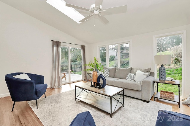 3828 Chandworth Rd, Charlotte, NC 28210 - living room with a ceiling fan, light wood-type flooring, vaulted ceiling, a skylight, and baseboards