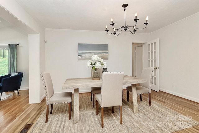 3828 Chandworth Rd, Charlotte, NC 28210 - dining area with a chandelier, light wood finished floors, baseboards, and ornamental molding