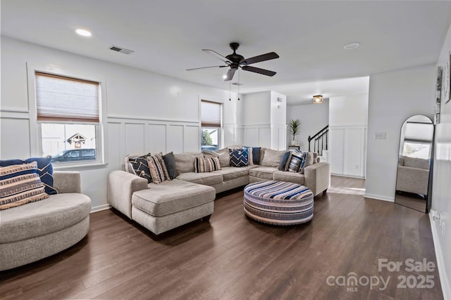 living room featuring ceiling fan and dark hardwood / wood-style flooring