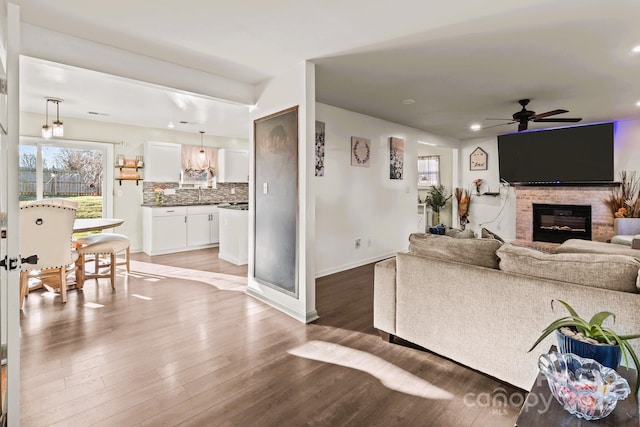 living room featuring ceiling fan and dark hardwood / wood-style floors