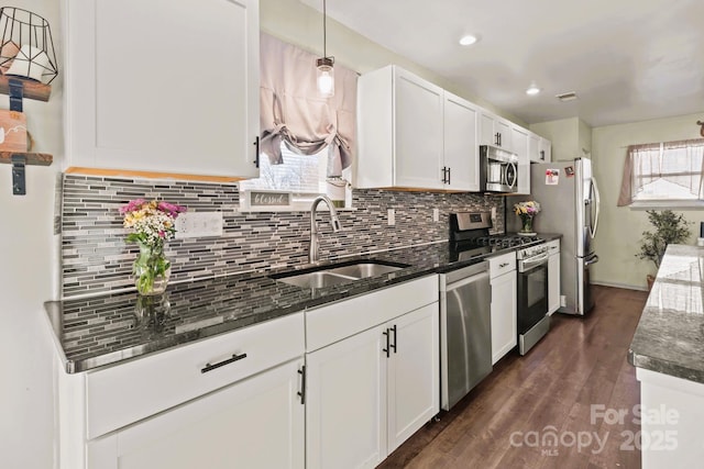 kitchen featuring stainless steel appliances, white cabinetry, sink, and pendant lighting