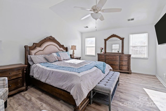 bedroom featuring multiple windows, lofted ceiling, ceiling fan, and light hardwood / wood-style flooring