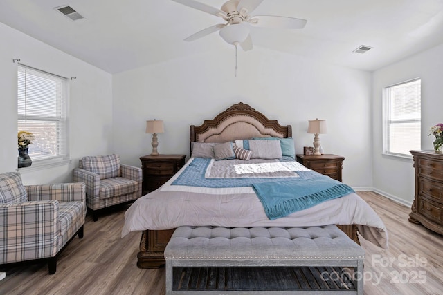 bedroom featuring ceiling fan, multiple windows, and light wood-type flooring