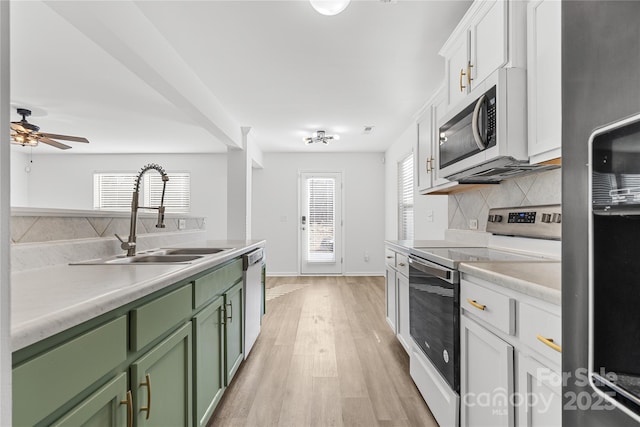 kitchen featuring white cabinetry, green cabinetry, decorative backsplash, sink, and stainless steel appliances