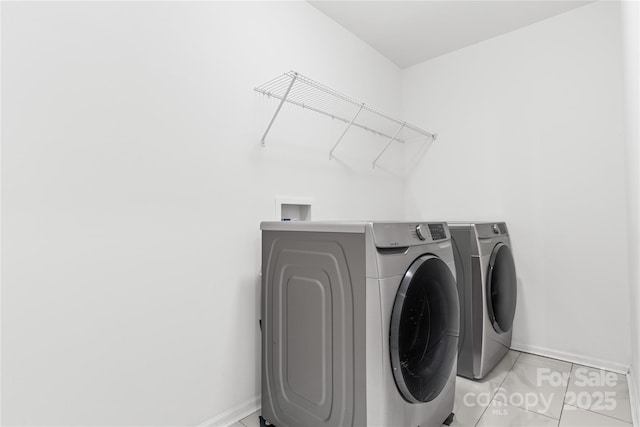 washroom with washer and clothes dryer and light tile patterned floors