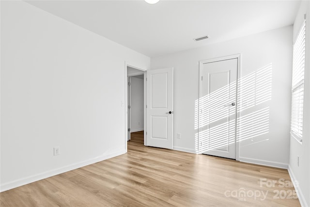 unfurnished bedroom with a closet and light hardwood / wood-style flooring