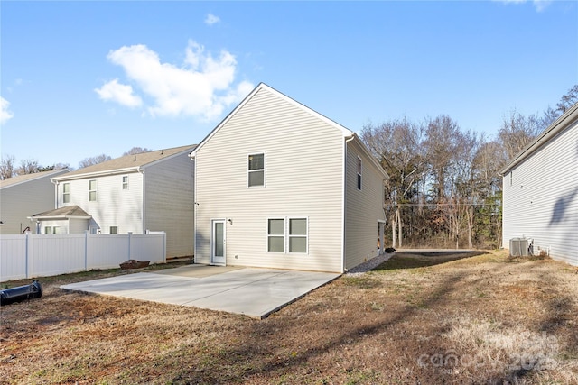 back of house with central air condition unit, a yard, and a patio