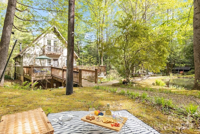 view of yard with a deck with water view