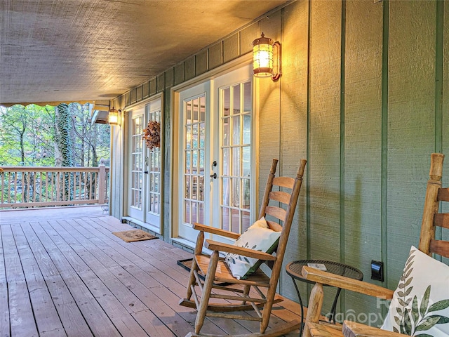 wooden terrace featuring covered porch and french doors