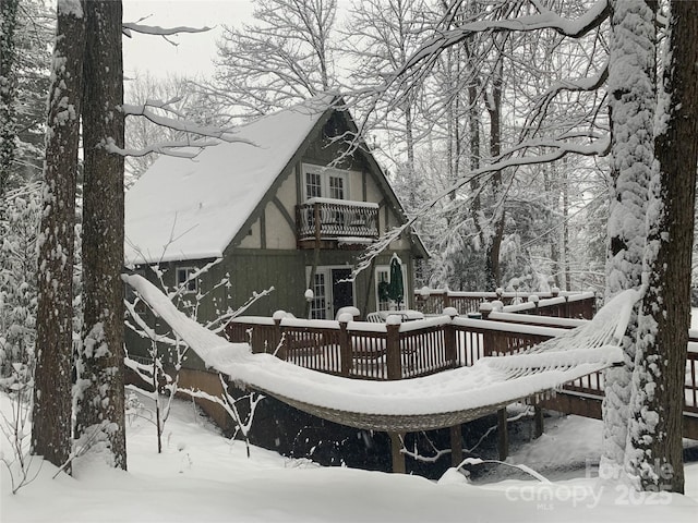snow covered property featuring a deck and a balcony