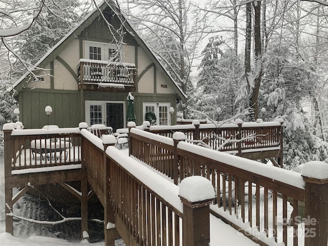 snow covered property with a wooden deck