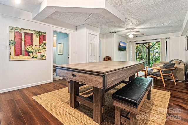 rec room featuring a ceiling fan, dark wood-style flooring, a textured ceiling, visible vents, and baseboards