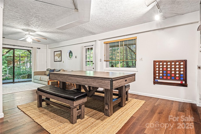 dining area featuring a healthy amount of sunlight, a textured ceiling, and wood finished floors