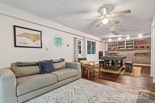 living room with a ceiling fan, a textured ceiling, pool table, and hardwood / wood-style floors