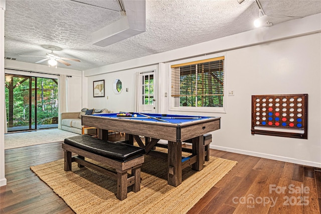 rec room with a textured ceiling, plenty of natural light, and wood finished floors