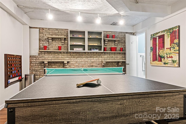 recreation room with visible vents, a textured ceiling, and track lighting