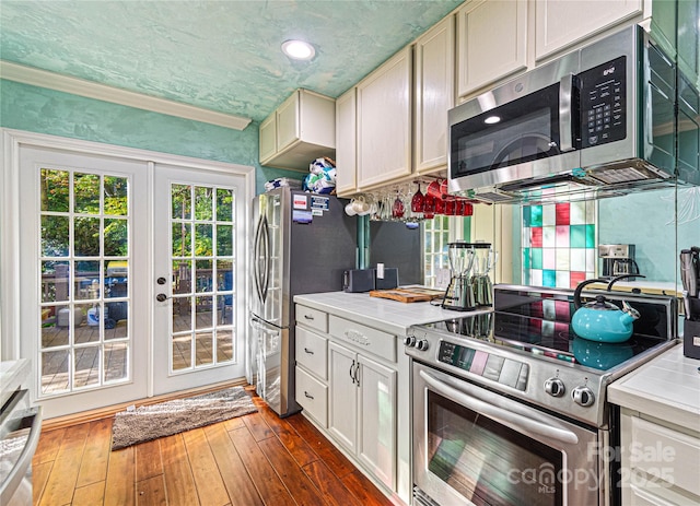 kitchen featuring light countertops, appliances with stainless steel finishes, french doors, and dark wood-type flooring