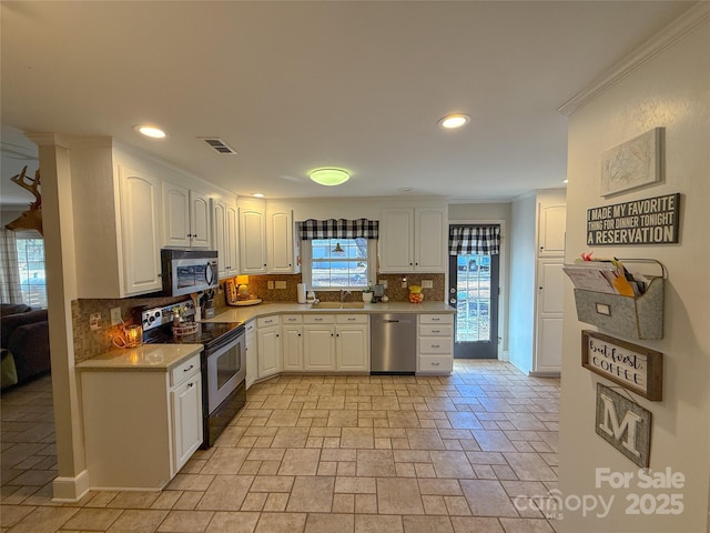 kitchen featuring light countertops, visible vents, backsplash, appliances with stainless steel finishes, and white cabinetry