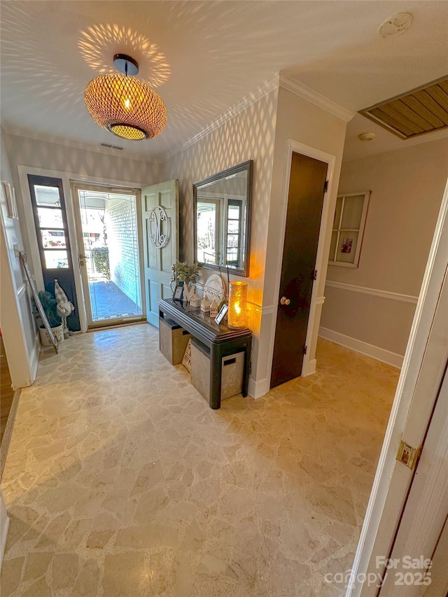 interior space featuring stone finish flooring, ornamental molding, visible vents, and baseboards