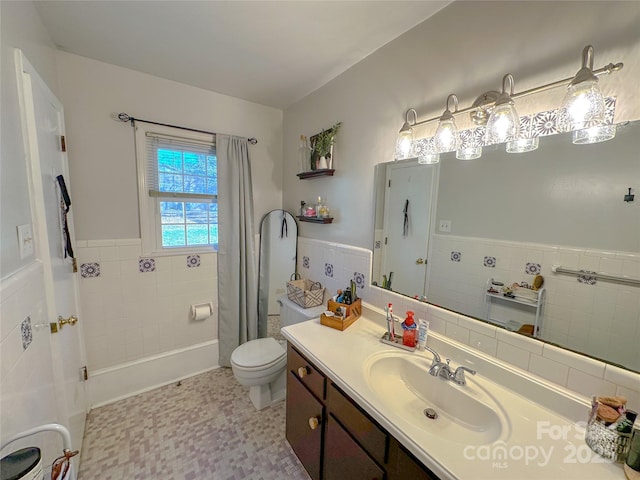 bathroom featuring wainscoting, toilet, tile walls, and vanity