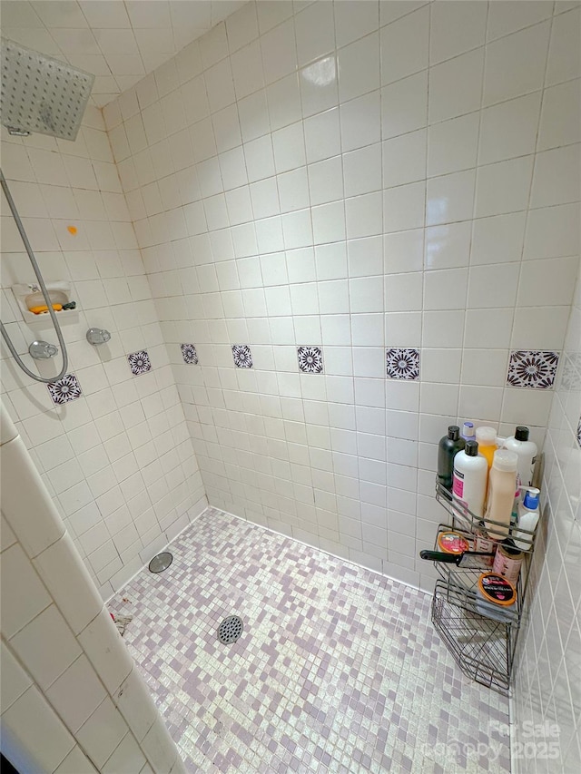 bathroom featuring a tile shower and tile walls